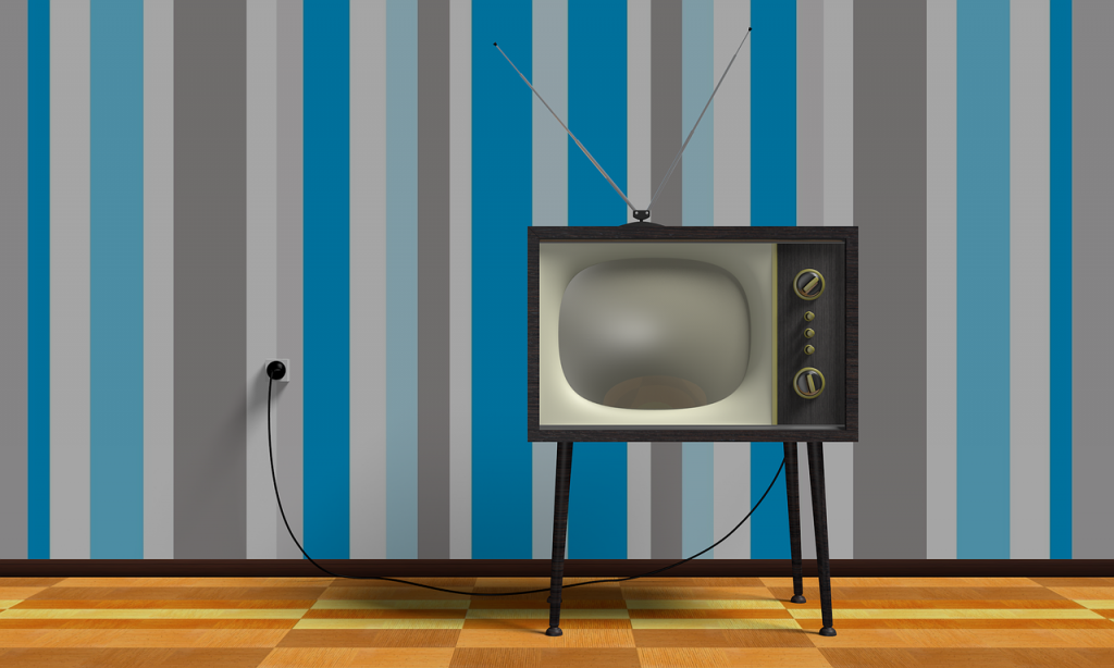 Das Bild zeigt einen Retro Fernseher vor Retro Tapete